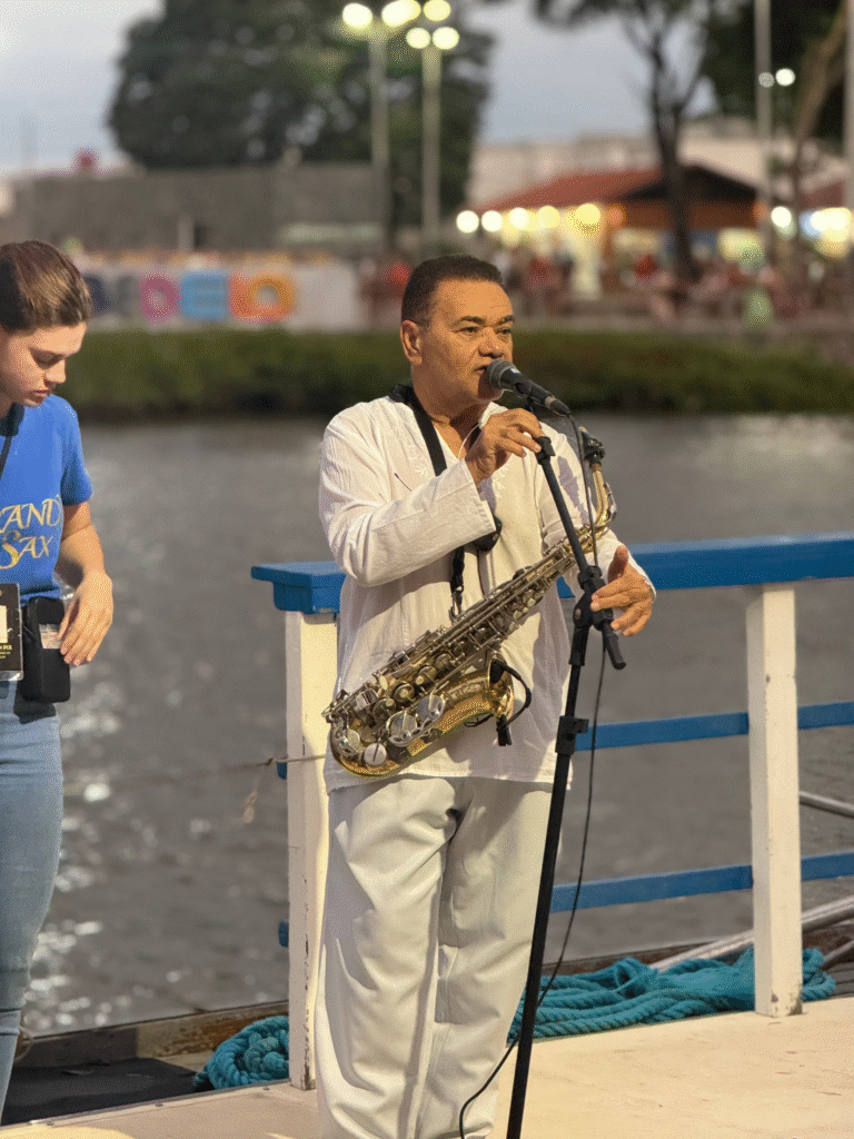 Taças de espumante sendo brindadas com o pôr do sol ao fundo no barco.