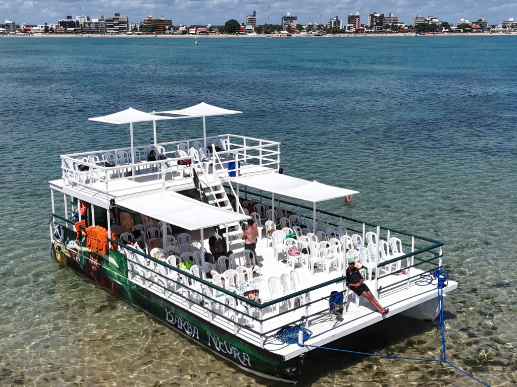 Vista aérea do banco de areia avermelhada da Ilha de Areia Vermelha cercada por mar turquesa.