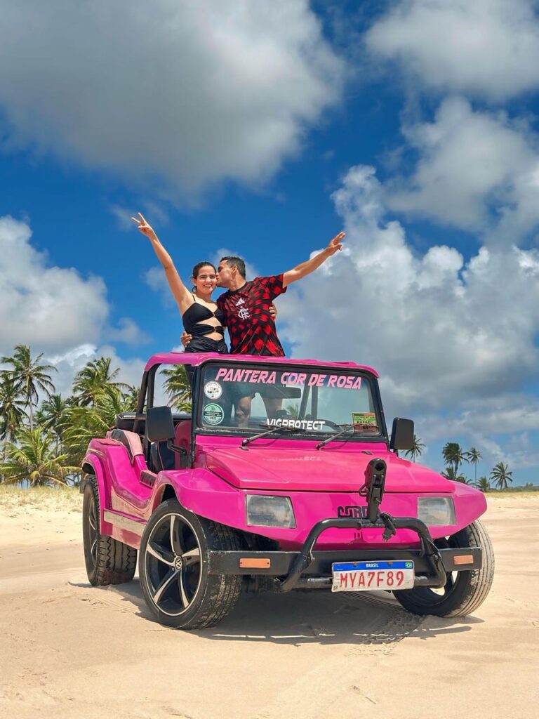 Buggy parado no topo da falésia no Mirante Dedo de Deus com vista panorâmica da praia.