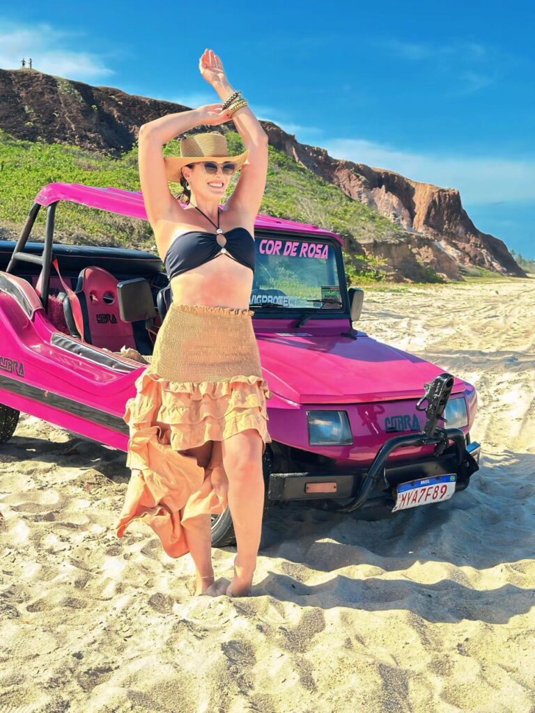 Bugueiro da Paraíba Náuticos tirando foto criativa dos turistas pulando na praia.