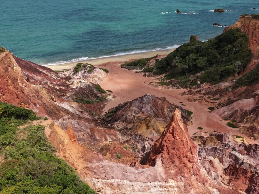 Quadriciclo estacionado próximo às formações coloridas das falésias do Castelo da Princesa na Paraíba.