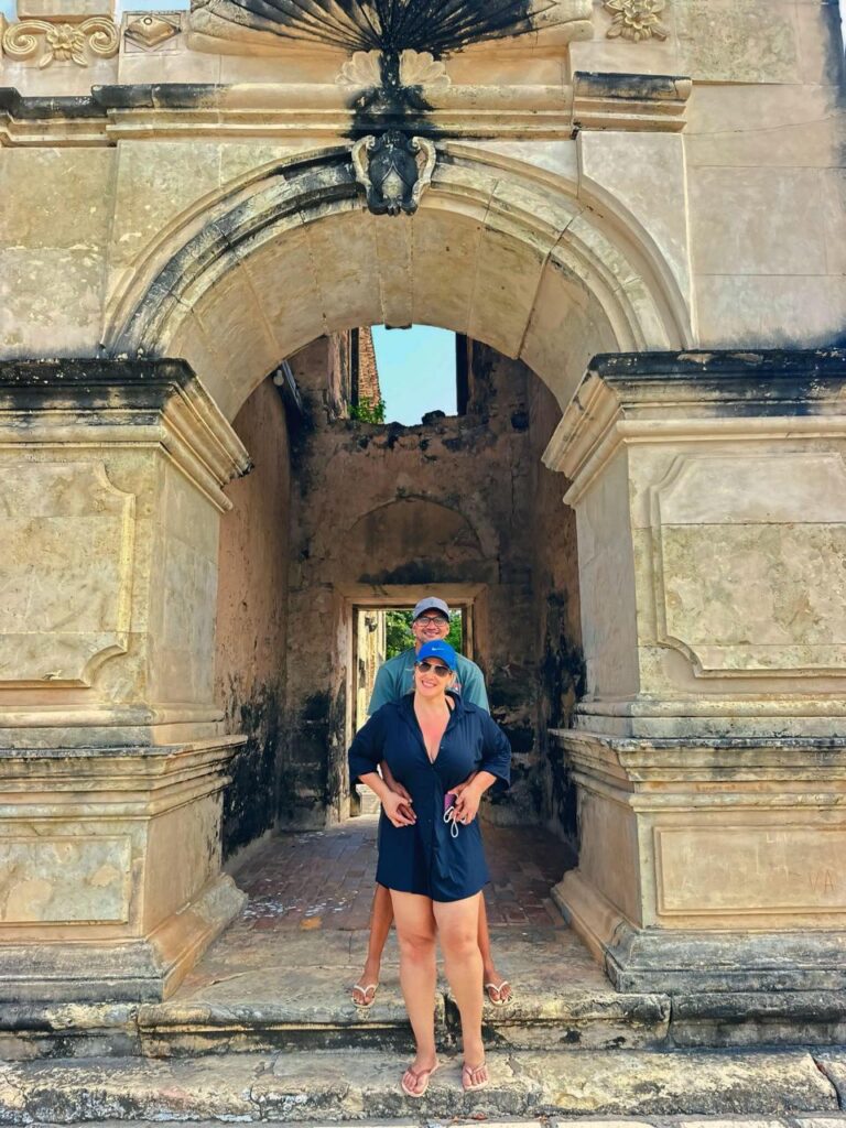 Ruínas da Igreja de Bom Sucesso com uma árvore gameleira a crescer por cima das paredes de pedra.