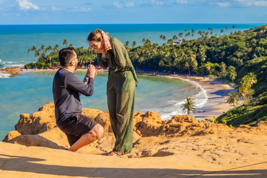 Turistas tirando foto embaixo da Pedra Furada na Praia do Amor em Jacumã.