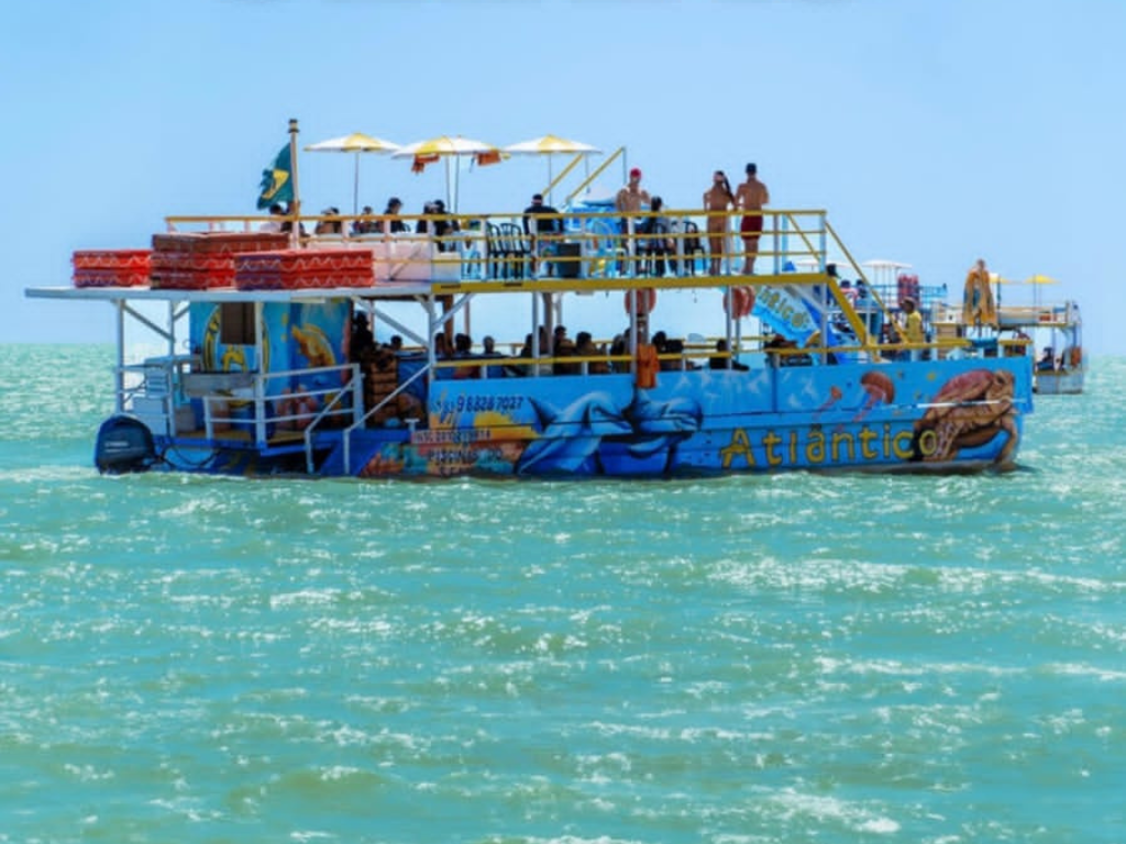 Turistas usando coletes salva-vidas entrando na água com auxílio da equipe da Paraíba Náuticos.
