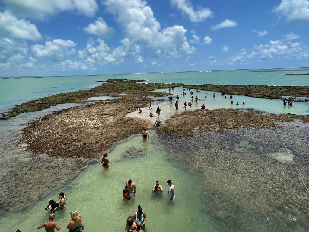 Turista deitado na rede ou banco do barco tomando sol e relaxando.