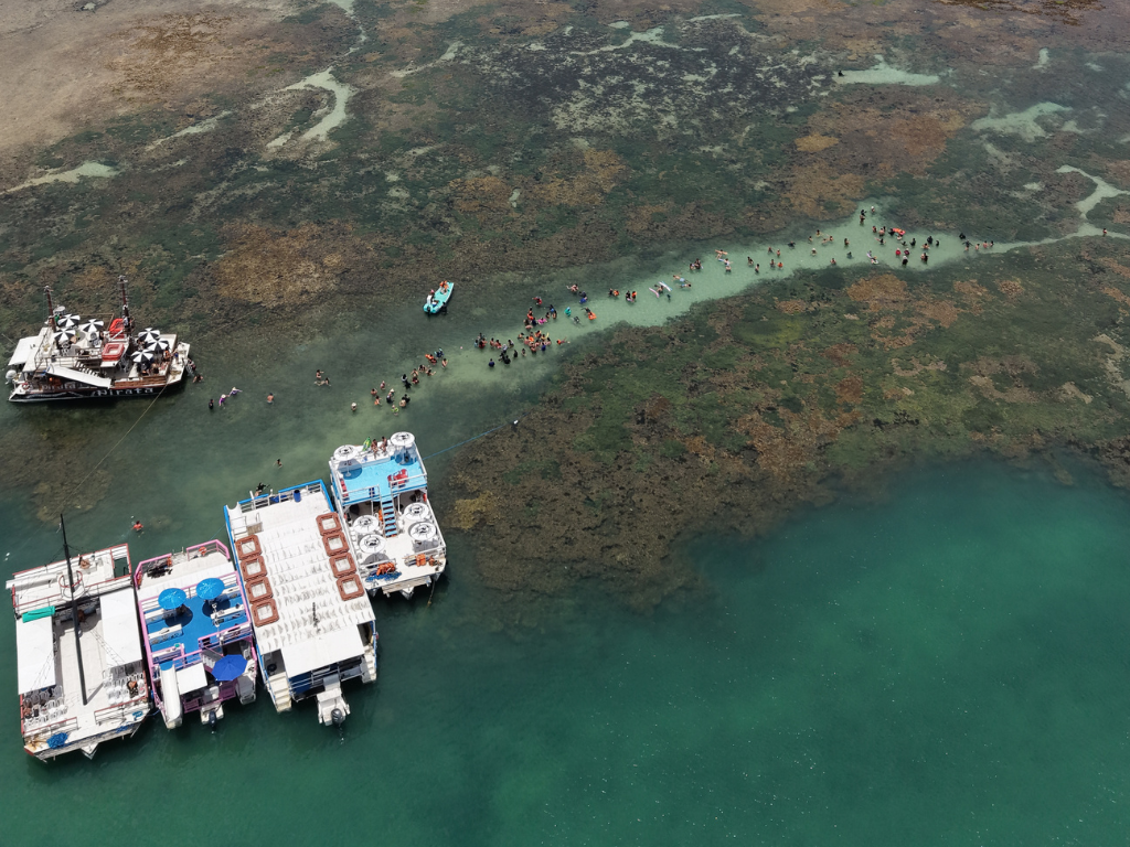 uristas brindando no catamarã da Paraíba Náuticos celebrando a chegada às Piscinas Naturais de Picãozinho nas férias.