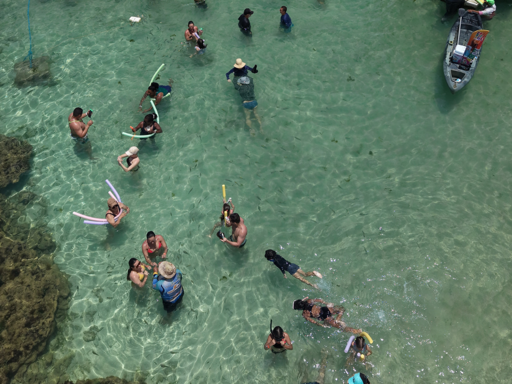 Vista aérea do banco de corais nas Piscinas do Seixas durante a maré baixa com mar azul turquesa.