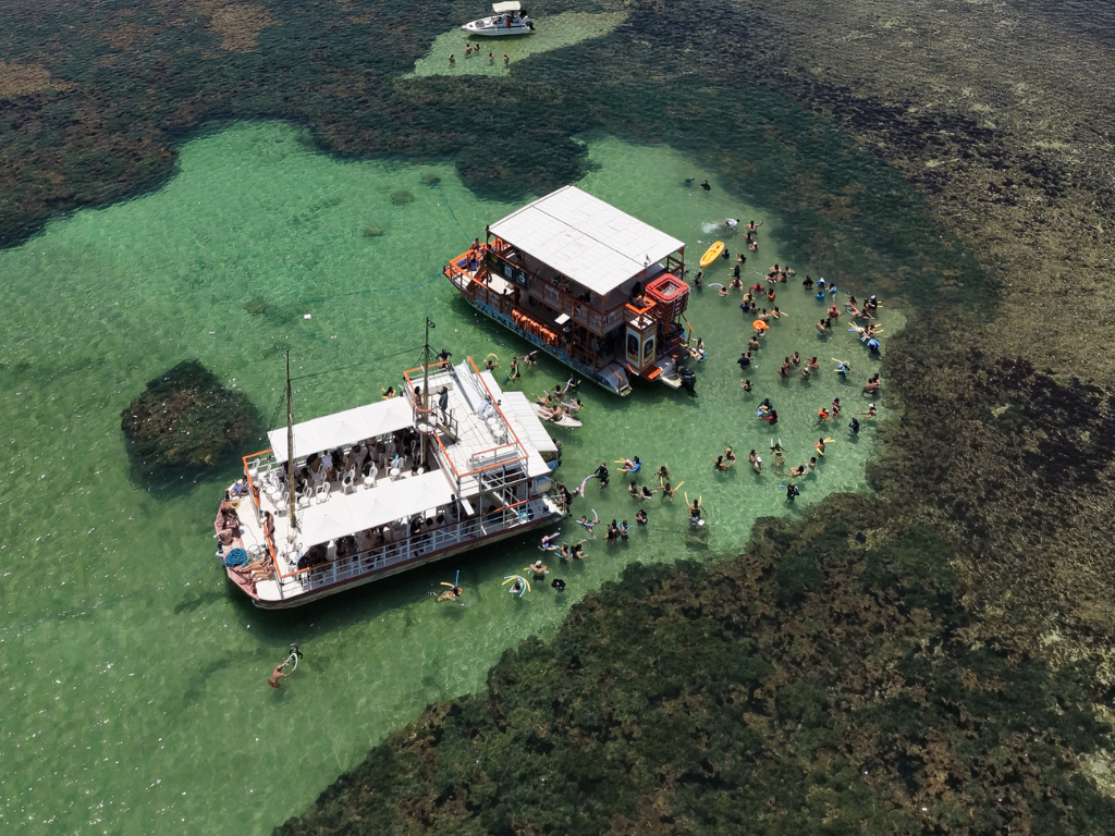Turistas mergulhando nas águas cristalinas das Piscinas do Seixas, localizadas no Ponto Mais Oriental das Américas.