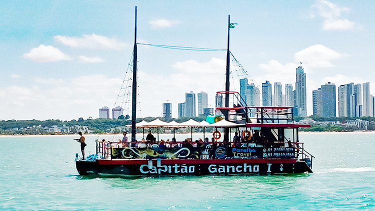 Vista da orla de Tambaú com o catamarã da Paraíba Náuticos saindo para Picãozinho.
