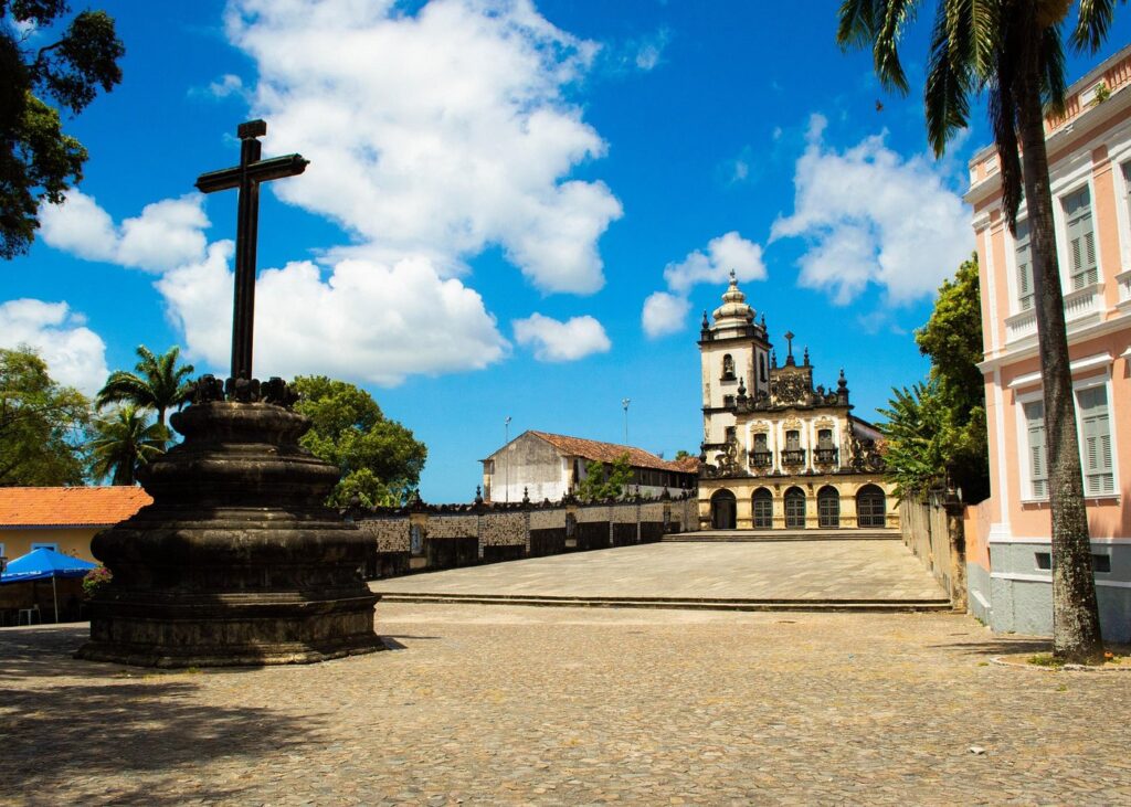 Fachada imponente do Centro Cultural São Francisco com o cruzeiro de pedra na frente.