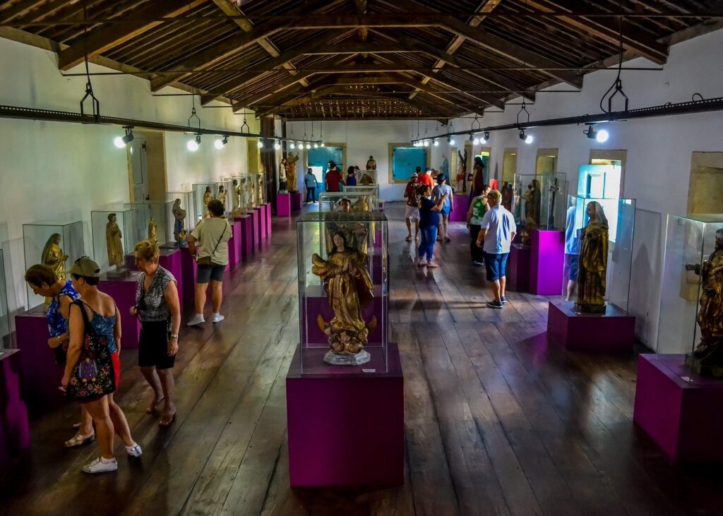 Corredor do Mercado de Artesanato Paraibano com redes, rendas e produtos de barro.