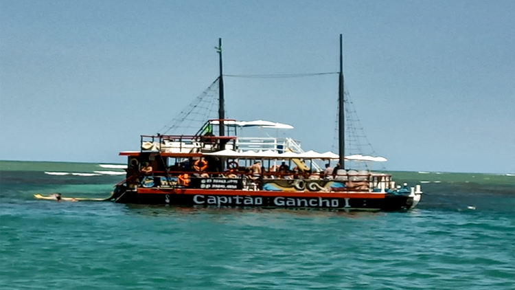 Turista cercado por dezenas de peixinhos "sargentinhos" nas águas de Picãozinho.