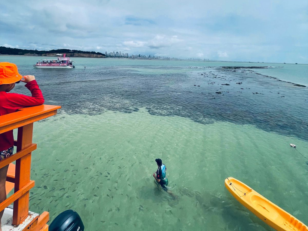 Detalhe da estrutura do catamarã com serviço de bordo e vista para o mar de João Pessoa.