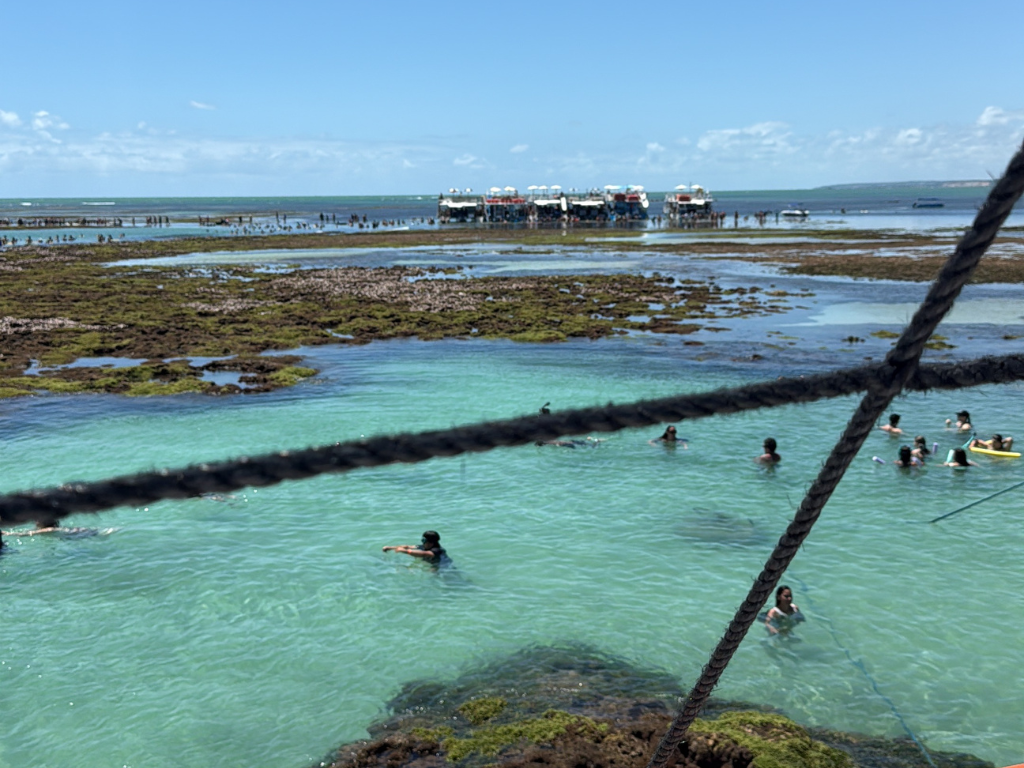 Turistas nadando nas águas transparentes e mornas da Praia do Seixas em João Pessoa.