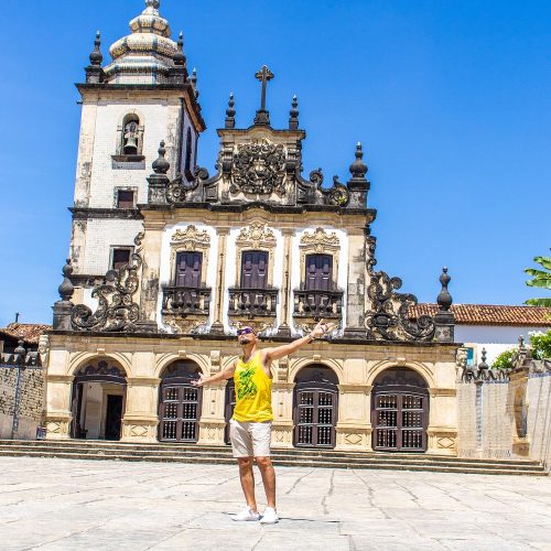 Turistas posando para foto no letreiro colorido "Eu Amo Jampa" na orla de Tambaú.