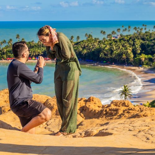 Turistas tirando foto embaixo da Pedra Furada na Praia do Amor em Jacumã.