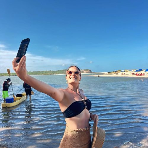 Turistas sorrindo com cabelos ao vento no banco de trás do buggy em movimento.