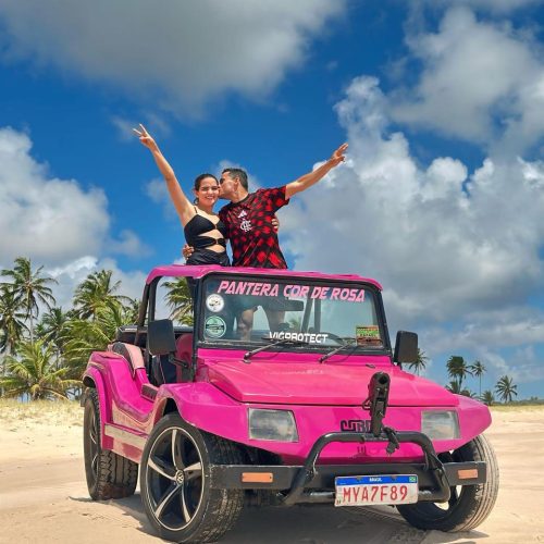 Buggy parado no topo da falésia no Mirante Dedo de Deus com vista panorâmica da praia.