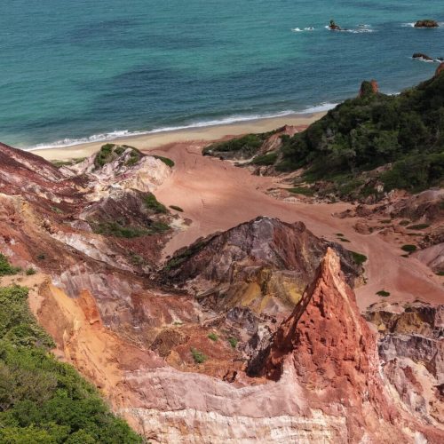 Quadriciclo estacionado próximo às formações coloridas das falésias do Castelo da Princesa na Paraíba.